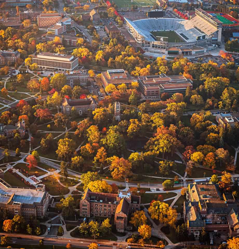 Michael Biggar standing on a university campus, wearing casual attire